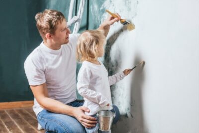 Father and Daughter painting a wall