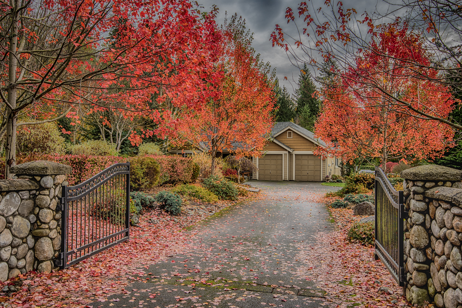 Gated home surrounded by trees with red leaves