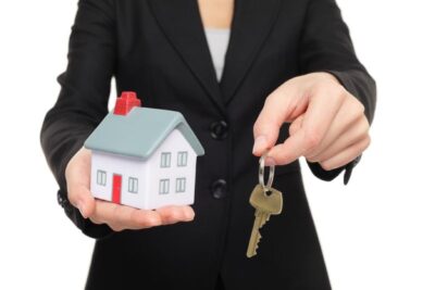 Realtor holding a key and a model house