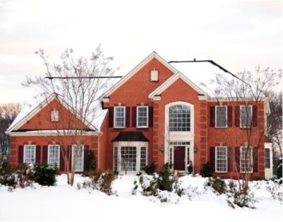 A large brick house covered in snow