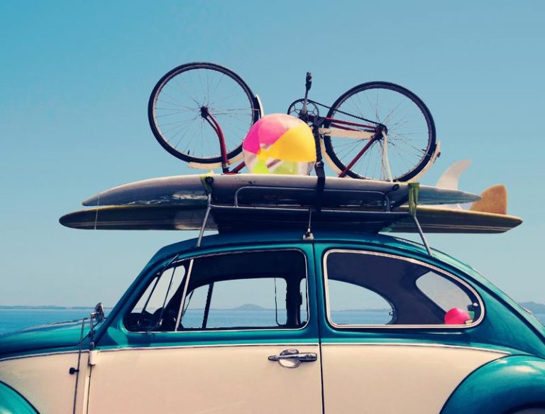 Car carrying a surfboard and a bicyle