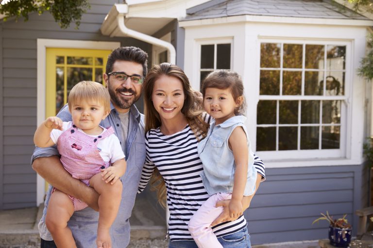 A picture of a family infront of a house