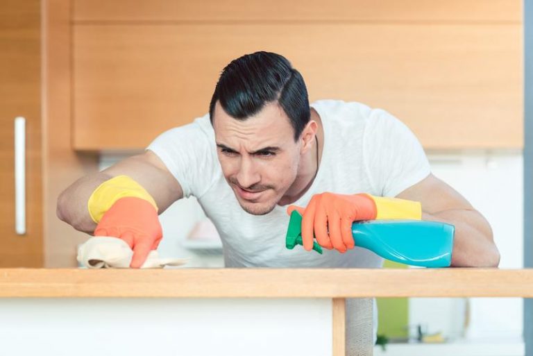 Man cleanin a table with cleaning tools